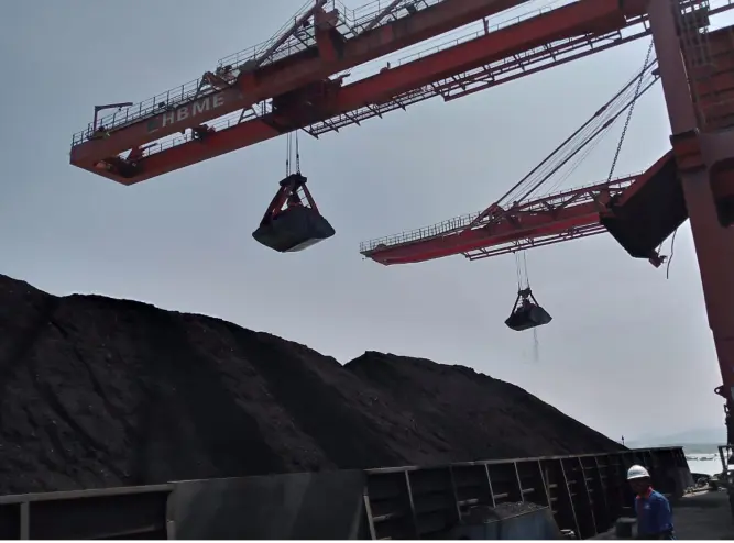 Discharging process of coal from barge using cranes.